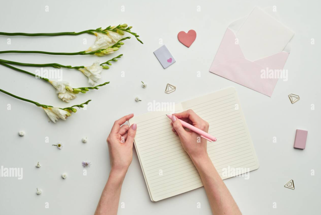 Hands writing on a floral monthly planner printed on high quality cardstock