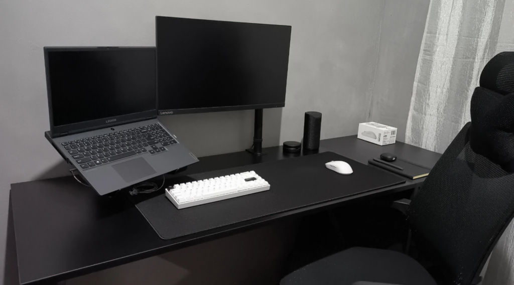 Minimalist desk setup with a physical moon phase calendar next to a laptop
